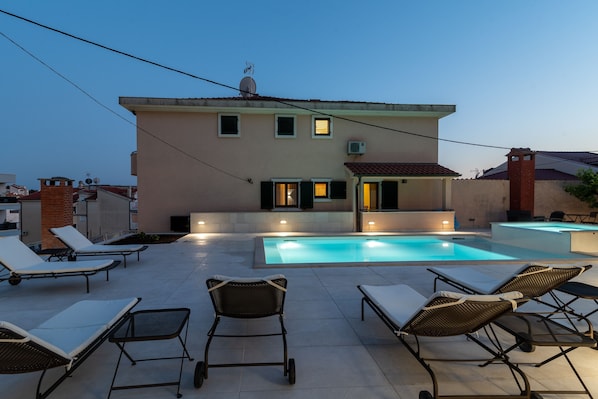 Outdoor pool, a heated pool, pool umbrellas, pool loungers