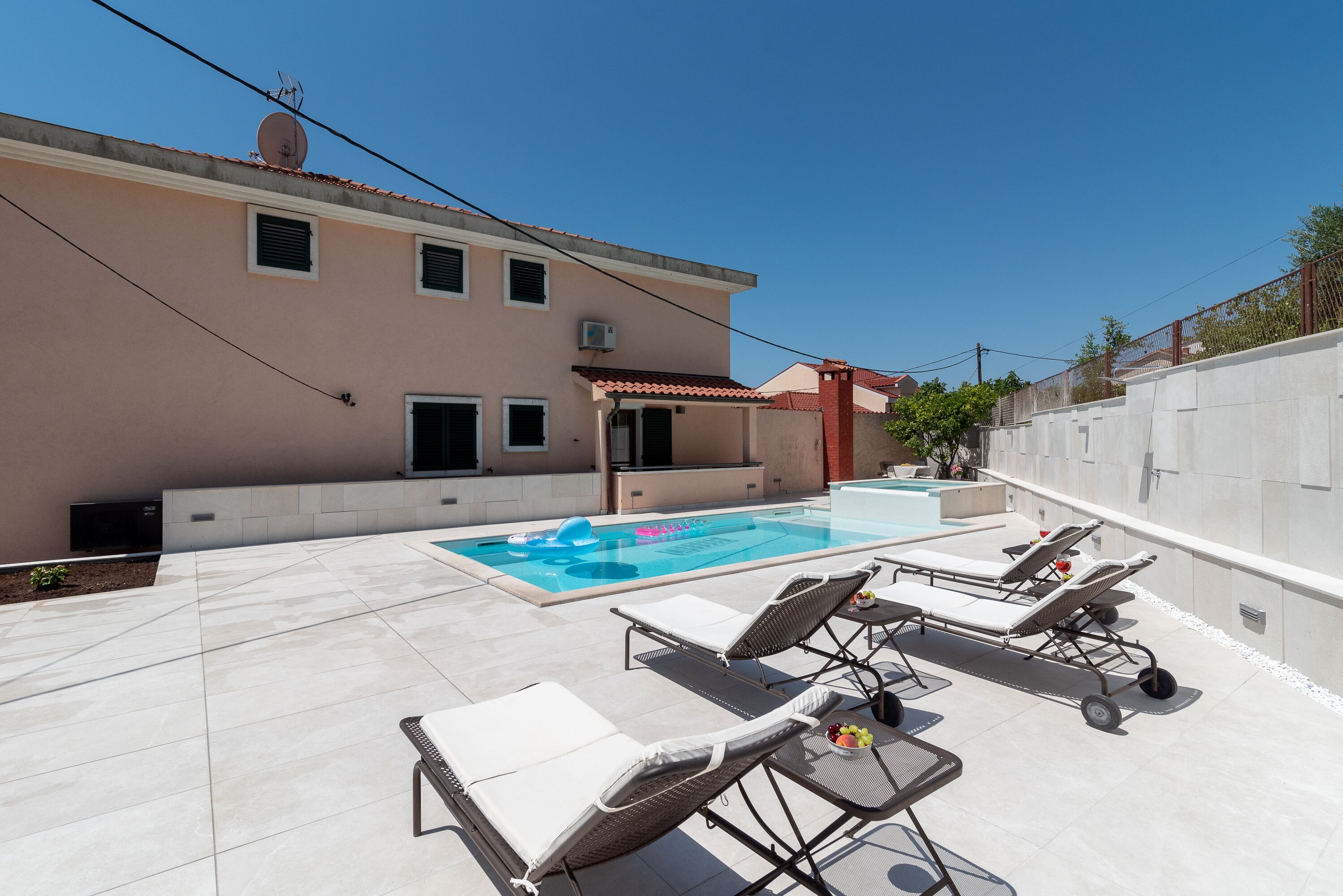 Un espace piscine aménagé sur le toit, avec des chaises longues et une piscine.