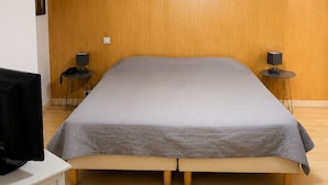 A room with a bed, two bedside tables, a desk with a computer, and a wall-mounted light fixture. - Auberge La Crémaillère (Villandraut)