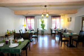 A dining area with wooden tables, chairs, and a chandelier. - Auberge La Crémaillère (Villandraut)