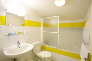Un baño con lavamanos, inodoro y bañera.