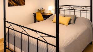 A four-poster bed with a headboard, a bedside table with a lamp, and a wall-mounted artwork. - Auberge La Crémaillère (Villandraut)