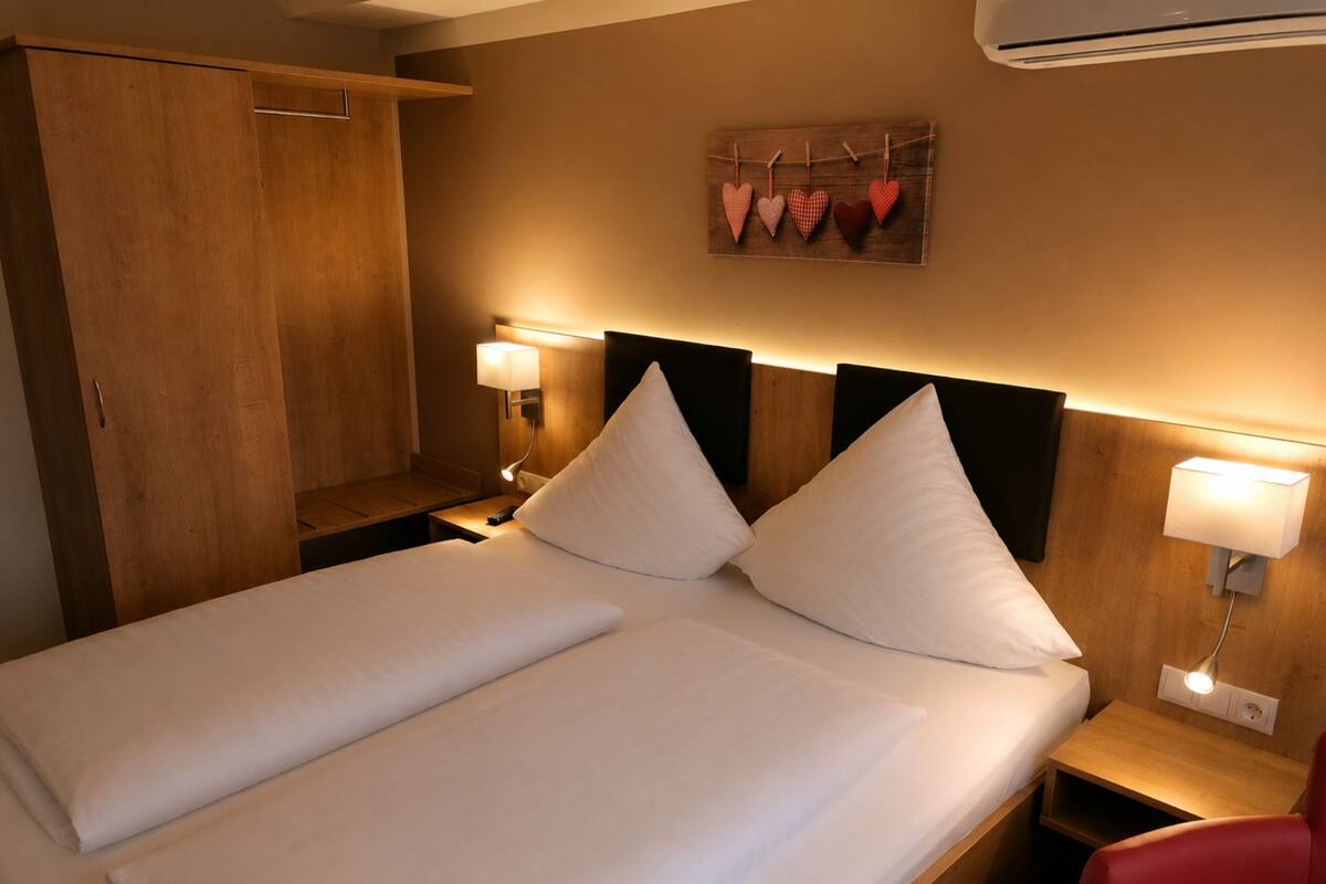 Hotelkamer met een bed, twee nachtkastjes, een garderobe en een decoratie aan de muur.