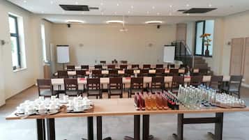 Uma sala de conferências com várias mesas, cadeiras e um palco.