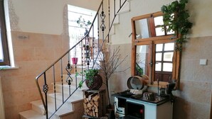 A staircase with a metal railing, a small table with kitchen items, and a mirror above it. - Landgasthof Niebler (Adelsdorf)