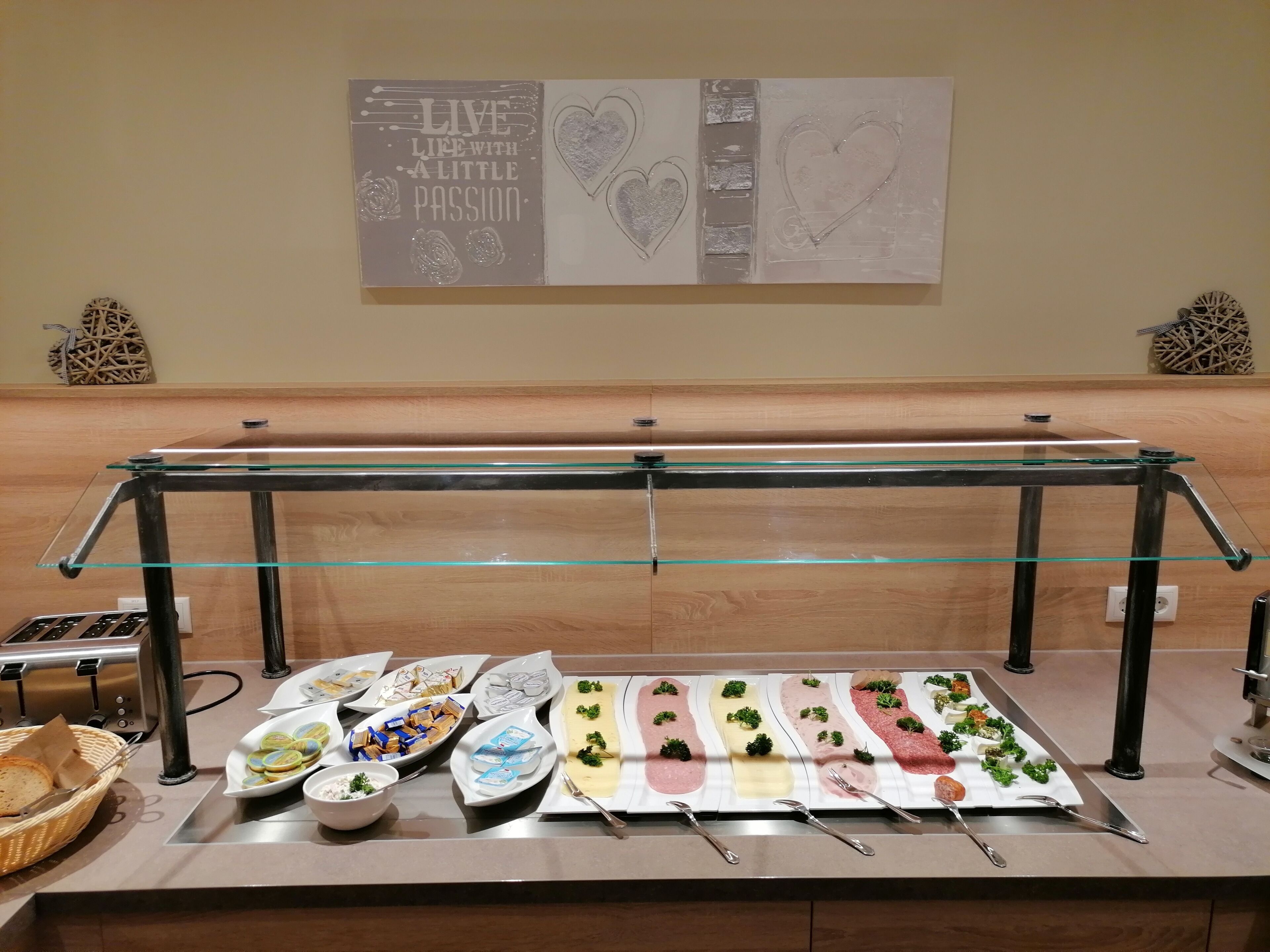 A buffet setup with various food items and a motivational poster on the wall.