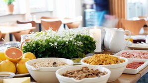 A breakfast buffet with various food items and a large pendant light.