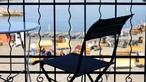 A balcony with a metal railing, a folding chair, and a small table.