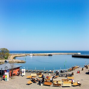 A waterfront promenade with benches and a small kiosk.