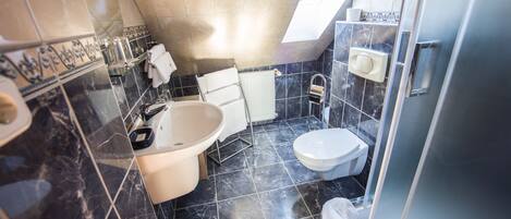 Un baño moderno con bañera, inodoro y zona de ducha.