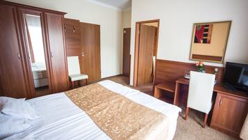 Une chambre d’hôtel équipée d’un lit, d’un bureau, d’une chaise et d’un téléviseur.