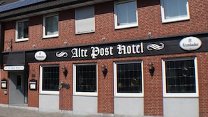 A hotel with a sign reading "Alte Post Hotel" and solar panels on the roof. - Alte Post Hotel (Schoeppingen)
