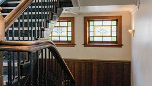 A staircase with wooden railings and a carpeted landing area. - The Cambridge Hotel & Backpackers (Wellington)