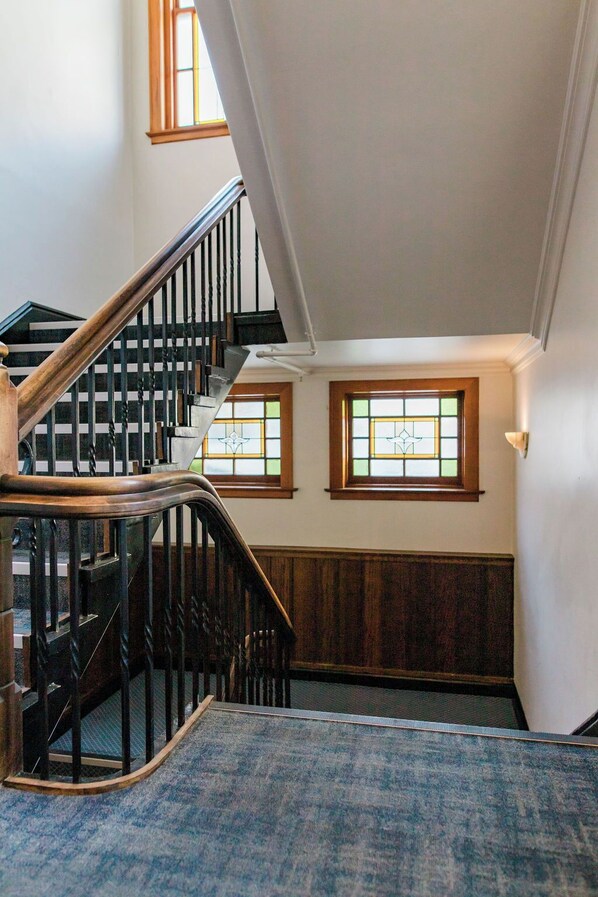 A staircase with wooden railings and a carpeted landing area.