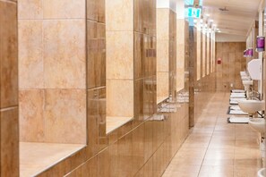 A long corridor with marble walls and sinks on one side.