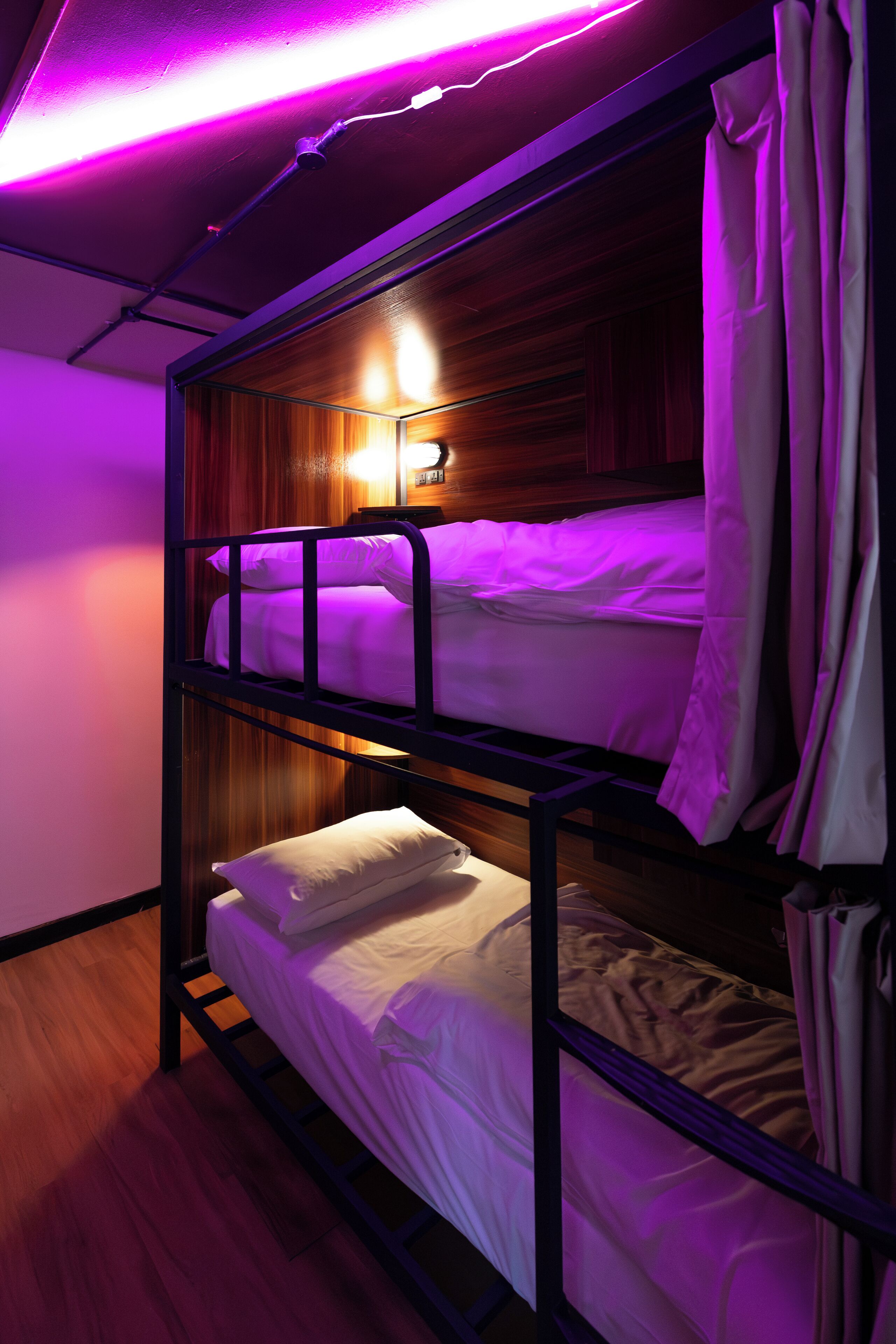 A bunk bed room with a wooden headboard and a wall-mounted light fixture.