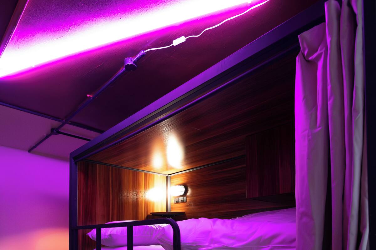 A bunk bed room with a wooden headboard and a wall-mounted light fixture.