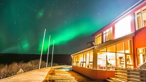 A building with a glass facade and a staircase leading to the entrance. - Hotel Glymur (Hvalfjarðarsveit)