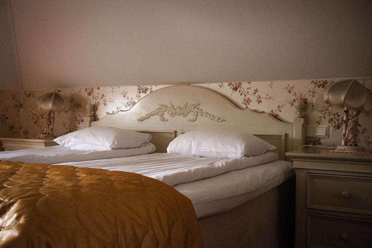 Ein Schlafzimmer mit einem Bett, zwei Nachttischen und einem Beistelltisch.