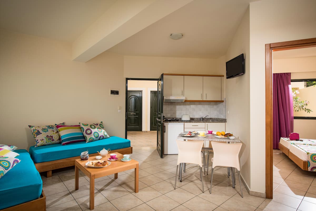 A compact living space with a kitchenette, a dining area, and a sofa.