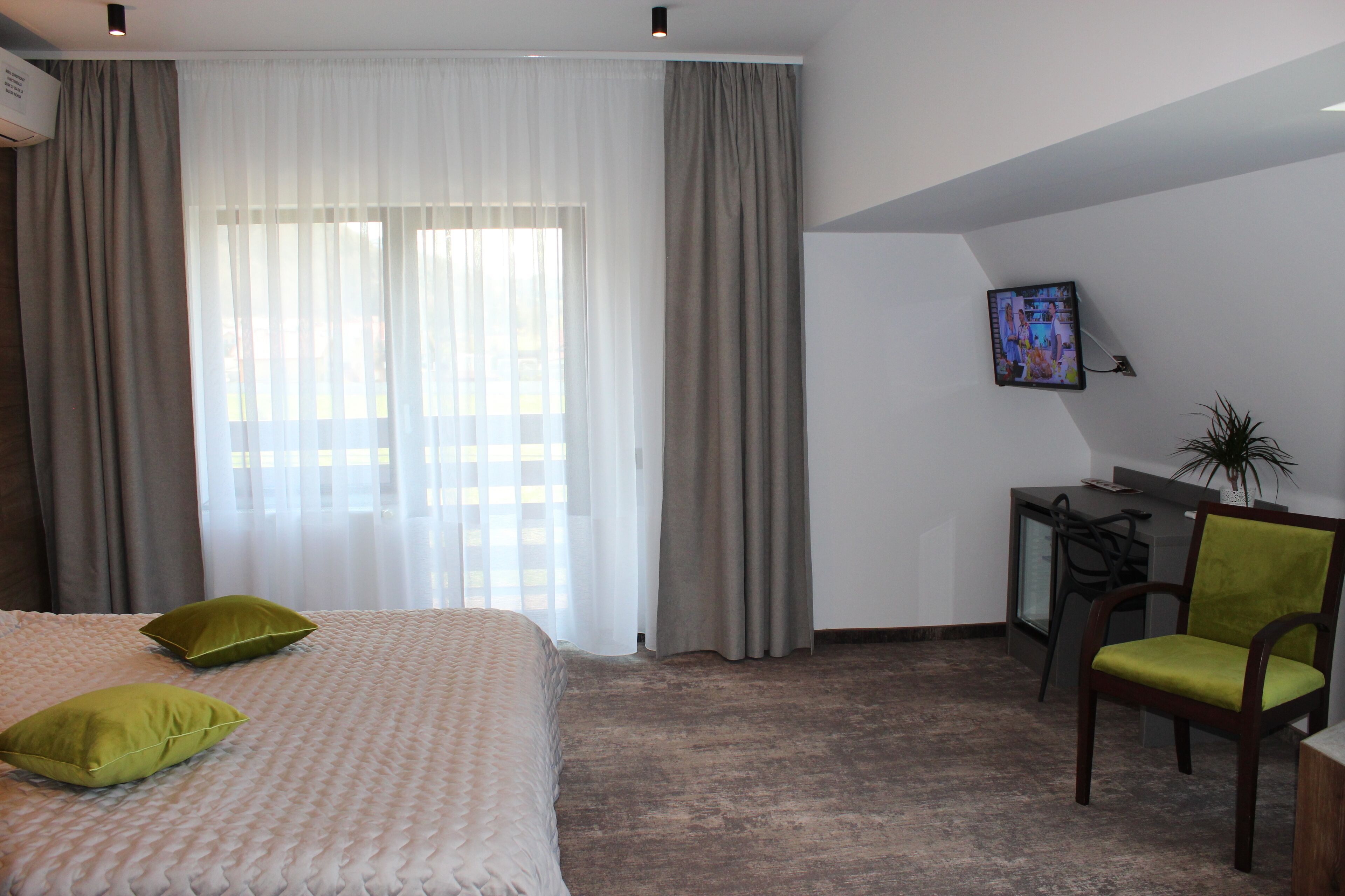 Een hotelkamer met een bed, bureau, stoel en televisie.