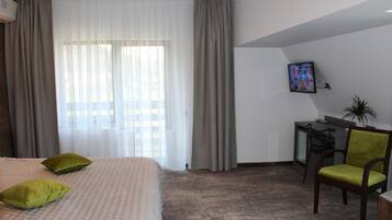 Een hotelkamer met een bed, bureau, stoel en televisie.