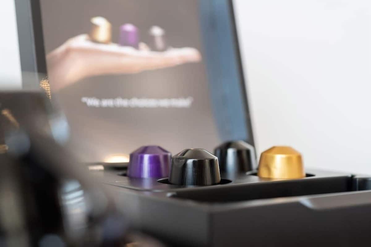 A close-up of a device with several metallic components, including a purple and a gold one, and a screen displaying a hand holding objects.