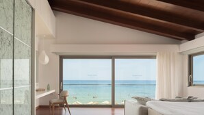 Une chambre moderne dotée d’une grande porte-fenêtre coulissante qui donne sur un balcon offrant une vue sur la plage.