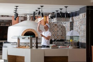 Un chef prepara comida en una cocina moderna con un horno grande, un lavamanos y un salpicadero con diseño.