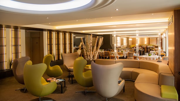 A modern hotel lobby with contemporary furniture, a dining area, and a reception desk. - Lacotel (Soorts-Hossegor)