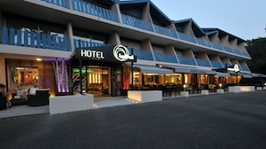 A hotel with a modern design, featuring a prominent 'HOTEL' sign, outdoor seating, and a well-lit entrance. - Lacotel (Soorts-Hossegor)