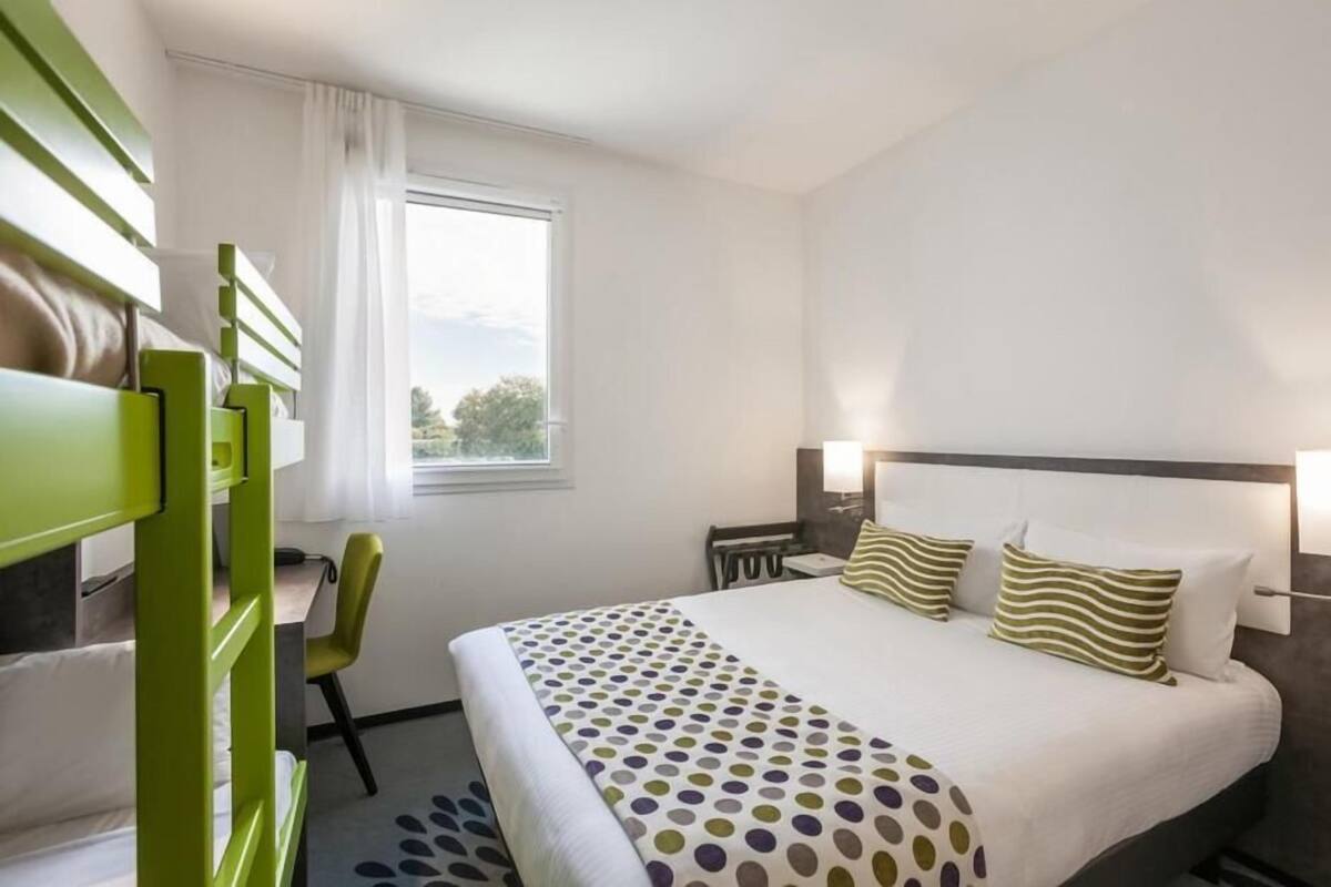 Een hotelkamer met een bed, een bureau en een stoel.