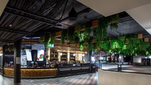 A modern bar area with a counter, seating, and hanging plants. - Mercure Sydney Liverpool (Prestons)