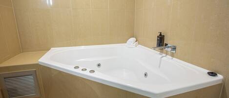 Un baño moderno con una bañera grande, un cabezal de ducha y un sistema de ventilación.