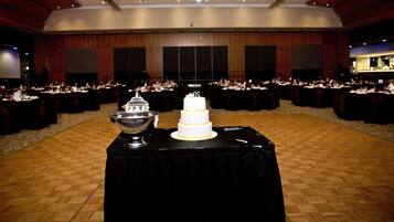 A large banquet hall with multiple round tables set for a formal event.