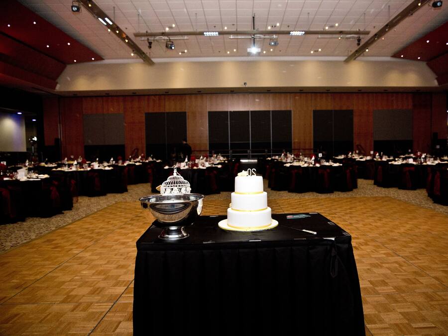 A large banquet hall with multiple round tables set for a formal event.