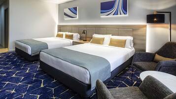 Habitación de hotel con dos camas, un sofá y un escritorio.