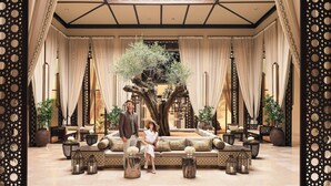 Un hall d’entrée spacieux agrémenté d’un grand arbre, de coins salon et d’un éclairage décoratif.