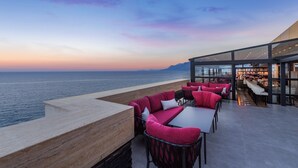 Een restaurant aan zee met terras, uitzicht op de zee en een modern interieur.