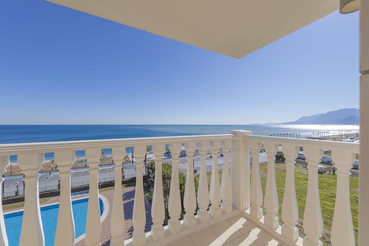 Un balcón con vistas al mar y a las montañas.