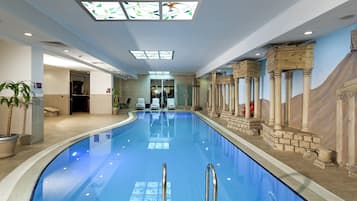 Una piscina techada, una piscina al aire libre de temporada, sombrillas