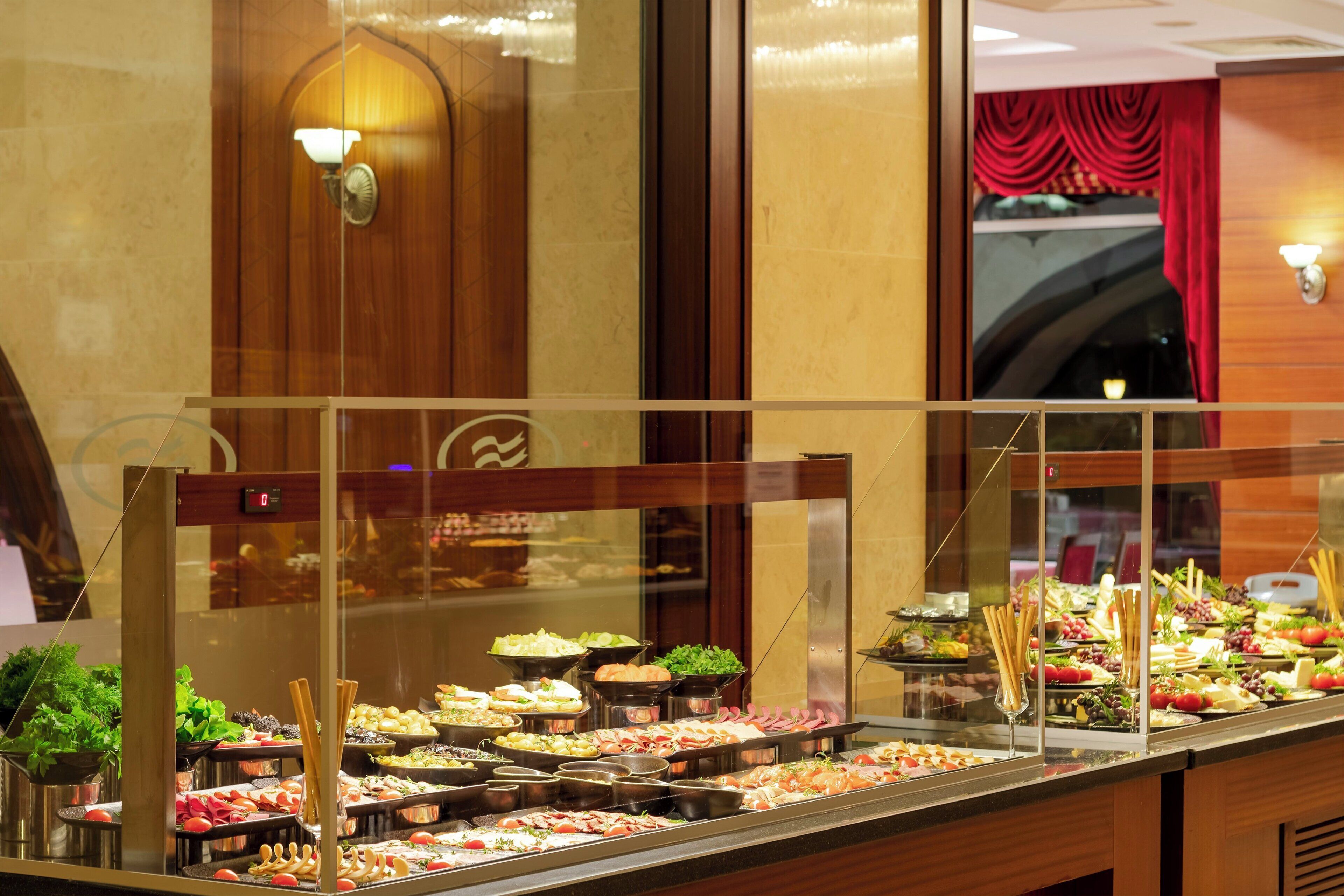 A buffet with various food items and a clock above it.