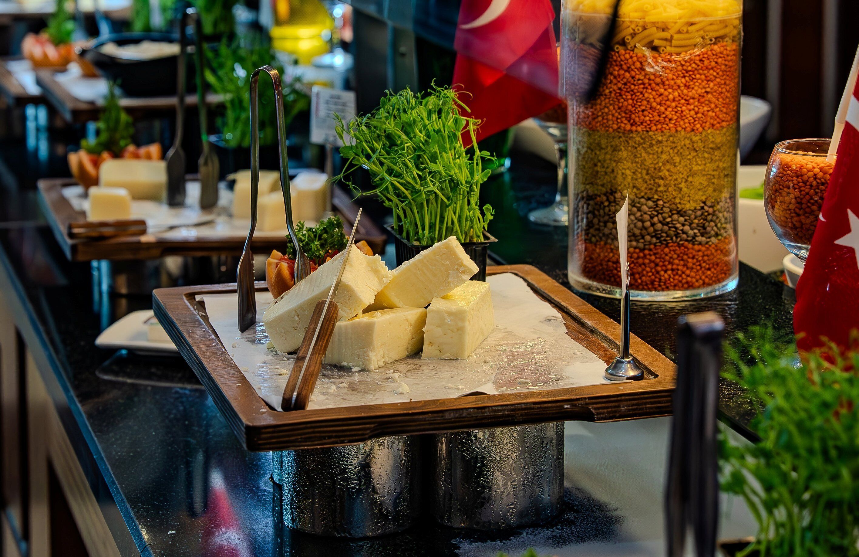 Disposição de buffet com diversos alimentos e utensílios.
