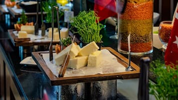 Disposição de buffet com diversos alimentos e utensílios.