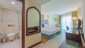 Una habitación de hotel con baño, una cama, un escritorio y una silla.