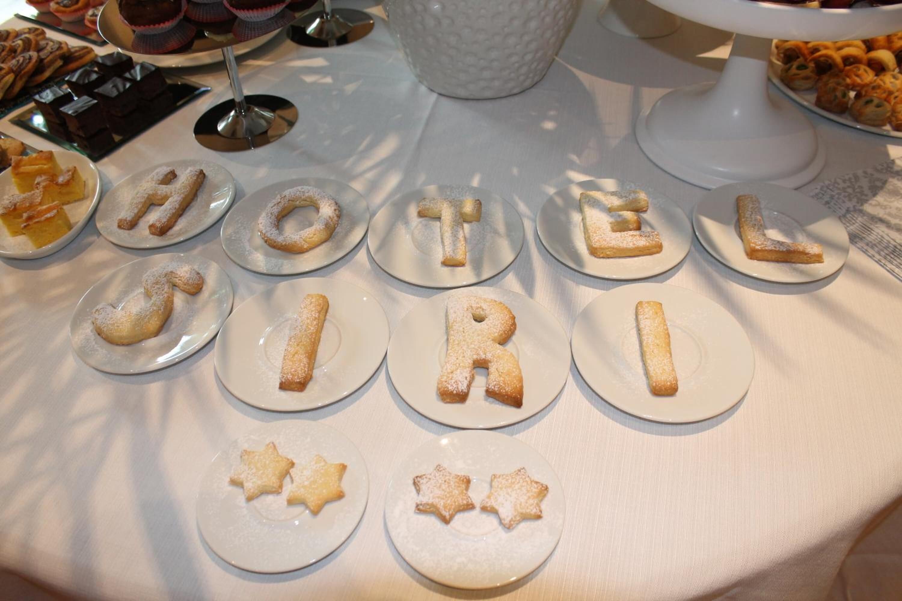 A table with plates of cookies spelling out "HOTEL GIRL" and star-shaped cookies.