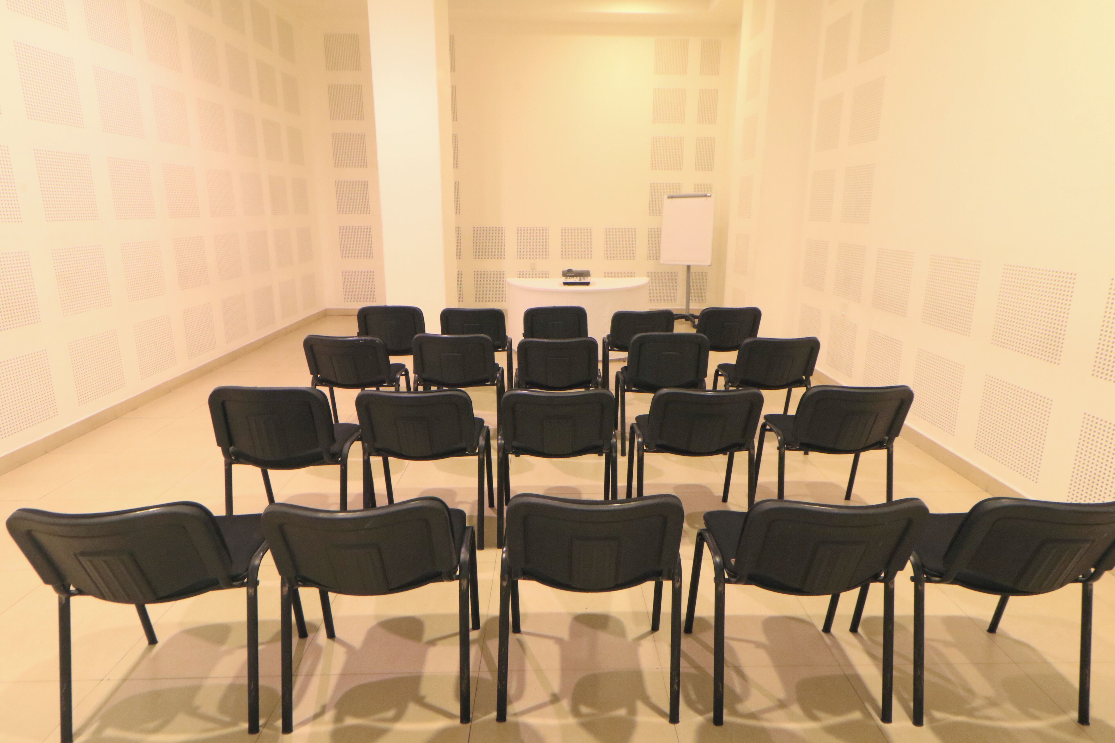 A conference room with a round table and chairs arranged in a semi-circle.