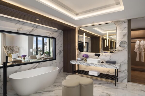 Ein modernes Badezimmer mit einer freistehenden Badewanne, einem мраморной Waschtisch und einem großen Spiegel.