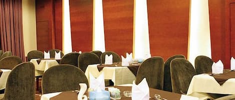 A conference room with tables set for a meeting, equipped with nameplates, notepads, and pens.