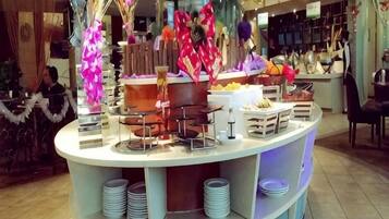 A buffet setup with various food items and decorative elements.
